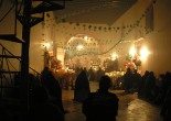 A photo of a community praying in a candle-lit and decorated church in San Ildefonso, Mexico